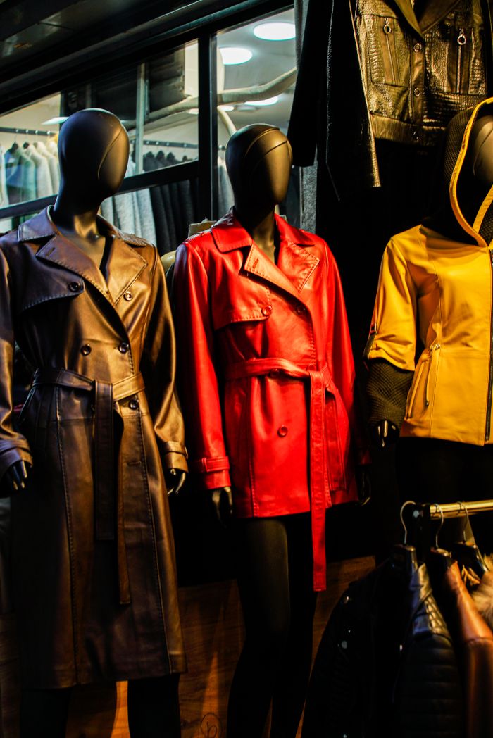 services-04 Colorful leather coats on mannequins in a stylish window display.