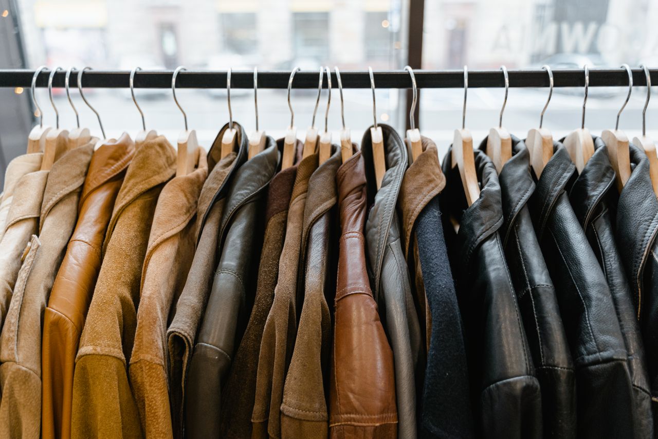 featured-images-03 A collection of leather and suede jackets hanging on a clothes rack in a stylish boutique.